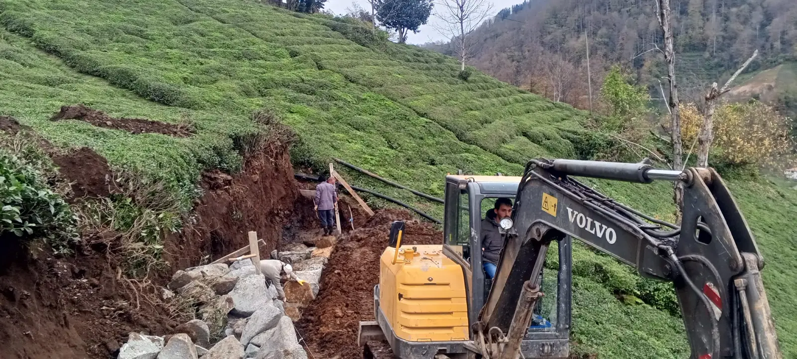 Yeşil arazide iş makinesiyle kazı çalışması